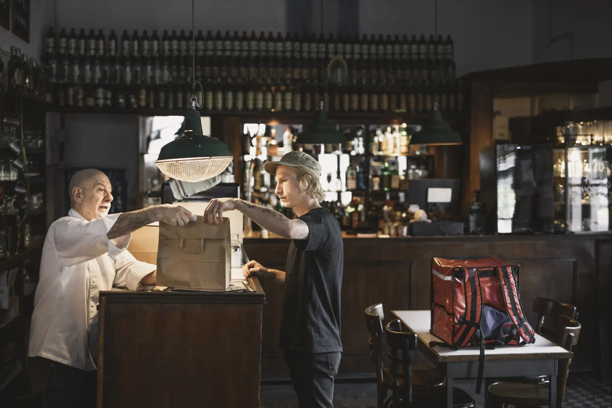 A delivery courier picking up an online order from a restaurant